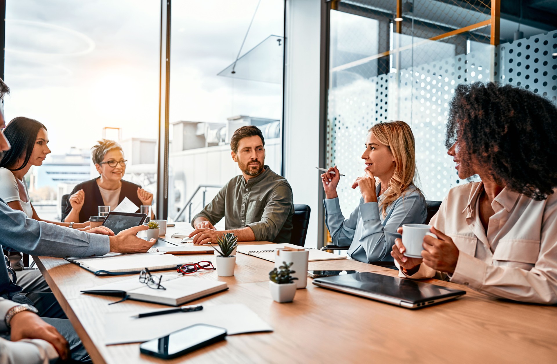 Business concept. Multinational professionals business people discussing daily topics by table in modern office. Business meeting.