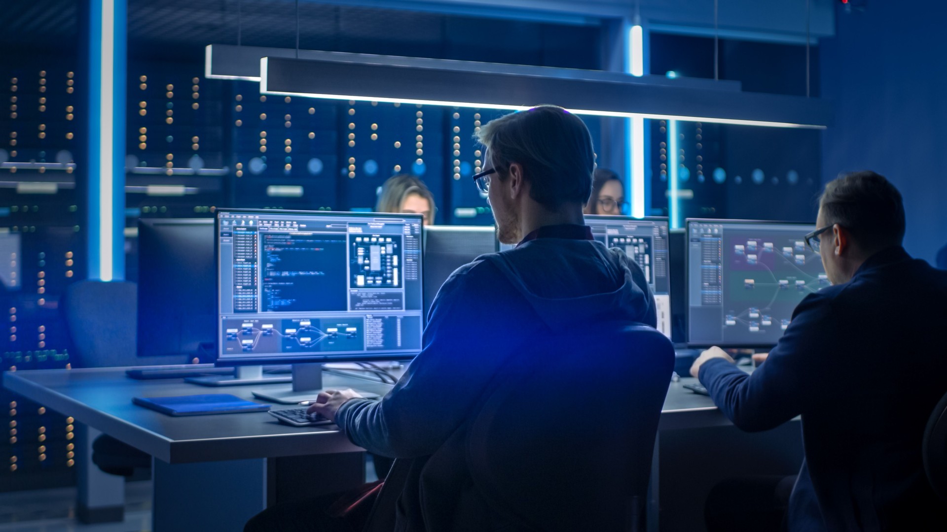 Team of IT Programers Working on Desktop Computers in Data Center Control Room. Young Professionals Writing on Sophisticated Programming Code Language